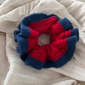 Détail d'un chouchou en maille bicolore rouge et bleu avec des bords à volants faits main - Bordure Bleu Marine