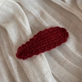 Detailed macro view of the wavy burgundy crochet wool drop hair clip with soft yarn texture - Red