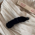 Detail of a black velvet banana hair clip with pleated texture on white linen cloth - Velvet Pleated Banana Clip / Black