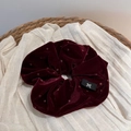 Détail d'un chouchou en velours bordeaux avec pois discrets et texture élégante sur lin - Chouchou en Velours Pressé à Chaud / Rouge