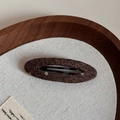 Detailed macro view of dark brown woven wool fabric texture on a minimalist oval hair clip - Coffee Polka Dot Hollow Oval