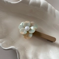 Dettaglio del fermaglio per capelli a fiore in acetato marmorizzato con perla centrale - Beige e Verde