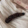 Close-up of leopard print velvet hair clip texture on a minimalist beige fabric background - Velvet Pleated Banana Clip / Leopard Print