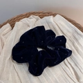 Gros plan détaillé du chouchou en velours bleu marine à pois sur un plateau - Chouchou en Velours Pressé à Chaud / Bleu Marine