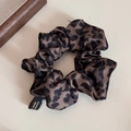 Dettaglio dell'elastico per capelli in raso leopardato con etichetta fatta a mano - Stampa leopardata
