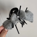 Détail d'une pince à cheveux avec nœud en tricot gris, perle et ruban noir élégant - Style Pince Nœud / Gris