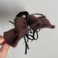 Détail de la pince à cheveux noeud tricoté en fil marron foncé avec rubans noirs et perle - Style Pince Nœud / Marron