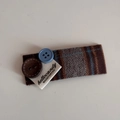Detail of a brown herringbone fabric hair clip with decorative buttons and woven label tag - Brown Gray Fabric Blue Coffee Button BB Clip