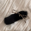Close-up of black plush hair clip with leopard print bow and gold metal pendant detail - Black