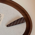Close-up of brown acetate hair claw clip with blue and white stripes on a wooden tray - Matte Stripe-Triangle Clip / Brown