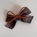 Detail of herringbone checkered fabric bow hair clip with orange suede cord ties - Brown Gray Fabric Orange Bow Hair Clip