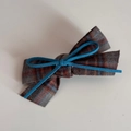 Detail of grey plaid bow hair clip with a contrasting blue suede center knot tie - Brown Gray Fabric Blue Bow Hair Clip