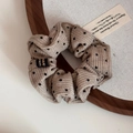 Dettaglio dell'elastico in maglia beige a pois con etichetta tessuta Korea su vassoio di legno - Albicocca Latte a Pois - Scrunchie Piccolo