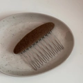 Detailansicht des braun stoffbezogenen Haarkamms mit Strickstruktur und Metallzähnen - Ovale Stoffkamm-Kaffee