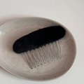 Detailed view of the soft black plush material and silver metal teeth on the hair comb - Black