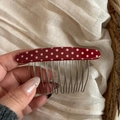 Close-up of retro red polka dot hair comb with metal teeth for styling updos - Red
