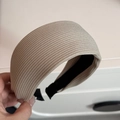 Detalle de una diadema de punto ancha beige que muestra la suave textura de canalé - Beige