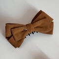 Detailed view of large vintage velvet bow hair clip with engraved Love gold plate - Yellow