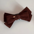 Close-up of a double-layered velvet bow hair clip with a golden Love engraved metal tag - Brown