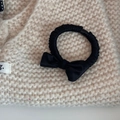 Detailed macro shot of a black satin bow scrunchie on a soft knitted background - Black (Basic Bow Style)