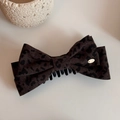Primer plano de la pinza para el pelo con lazo de leopardo y detalle de logo dorado - Leopardo Marrón Oscuro (FJ89583)