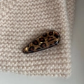 Dettaglio del fermaglio in acetato leopardato con incisione La France su maglia beige - Clip a goccia d'acqua / Tartaruga Caffè Giallo