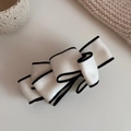 Detail of a beige multi-layer bow banana clip with black edges in soft faux suede fabric - Creamy White