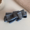 Detail of grey suede bow banana clip with blue stitching and black plastic closure - Cotton Gray