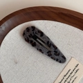 Detail of plush leopard print hair clip showing soft faux fur texture on a wooden tray - Gray Leopard Waterdrop
