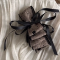 Detail of vintage fabric bow hair clip with black floral print and satin ribbon trim - Brown