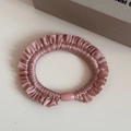 Detailed view of dusty pink silk elastic scrunchie with ruffled edges and resin buckle - Pink
