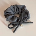 Detail of dark grey satin scrunchie featuring a wool bow, pearl charm, and gold tag - Pearl Bowknot-Gray