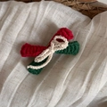 Détail d'une pince à cheveux de Noël au crochet faite main avec texture tricotée colorée - Nœud Rouge et Vert
