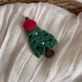 Dettaglio di un fermaglio per capelli a forma di albero di Natale in maglia con perle - Mela Albero di Natale