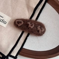Close-up of a brown felt heart hair clip with paw patterns on a warm wooden background - Coffee (Leopard Heart)