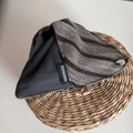 Vue macro détaillée du motif tricoté à rayures faites main et du logo en métal doré - Gris Foncé