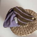 Détail de la pince à cheveux bicolore avec étiquette handmade et bouton pression doré - Violet et Café