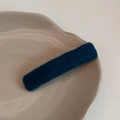 Gros plan détaillé d'une pince à cheveux rectangulaire en laine tricotée bleu foncé - Bleu