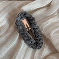 Detailed view of handmade dark grey wool knit hair clip on a beige linen fabric texture - Dark Gray