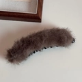 Dettaglio di un fermaglio a banana in morbido peluche marrone scuro soffice - Cachi