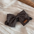 Detail of dark brown plaid fabric bow banana clip with a handmade leather label - Brown Plaid