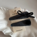 Dettaglio macro di fermagli per capelli in tweed grigio con fiocco in pelle su vassoio - Stile Fiocco Palla Peluche / Blu Notte