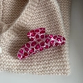 Makro-Detail einer rosa Leoparden-Haarklammer aus Acetat auf beigem Strickstoff - Large Fan Shape / Rosa Leopard