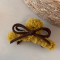 Detail of yellow plush bow hair claw clip with warm faux fur texture for winter - Yellow
