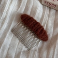 Detailed close-up of a handmade brown knit hair comb with a sturdy silver metal base - Hair Comb / Red