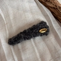 Dettaglio di un fermaglio per capelli in peluche grigio scuro con etichetta dorata - Grigio Scuro con Etichetta Dorata