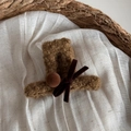 Detail einer braunen flauschigen Haarspange in Hutform mit Samtschleife und Pompons - Braun