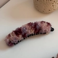 Vista macro dettagliata della trama di peluche e del motivo colorato sulla clip a banana - Rosa