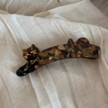 Detailansicht der Bananen-Haarklammer aus Acetat mit Schildpatt-Katze und goldenen Details - Kaffeebraun