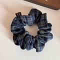 Detalle de un coletero de tela a cuadros azul y gris con una etiqueta de marca tejida - Azul